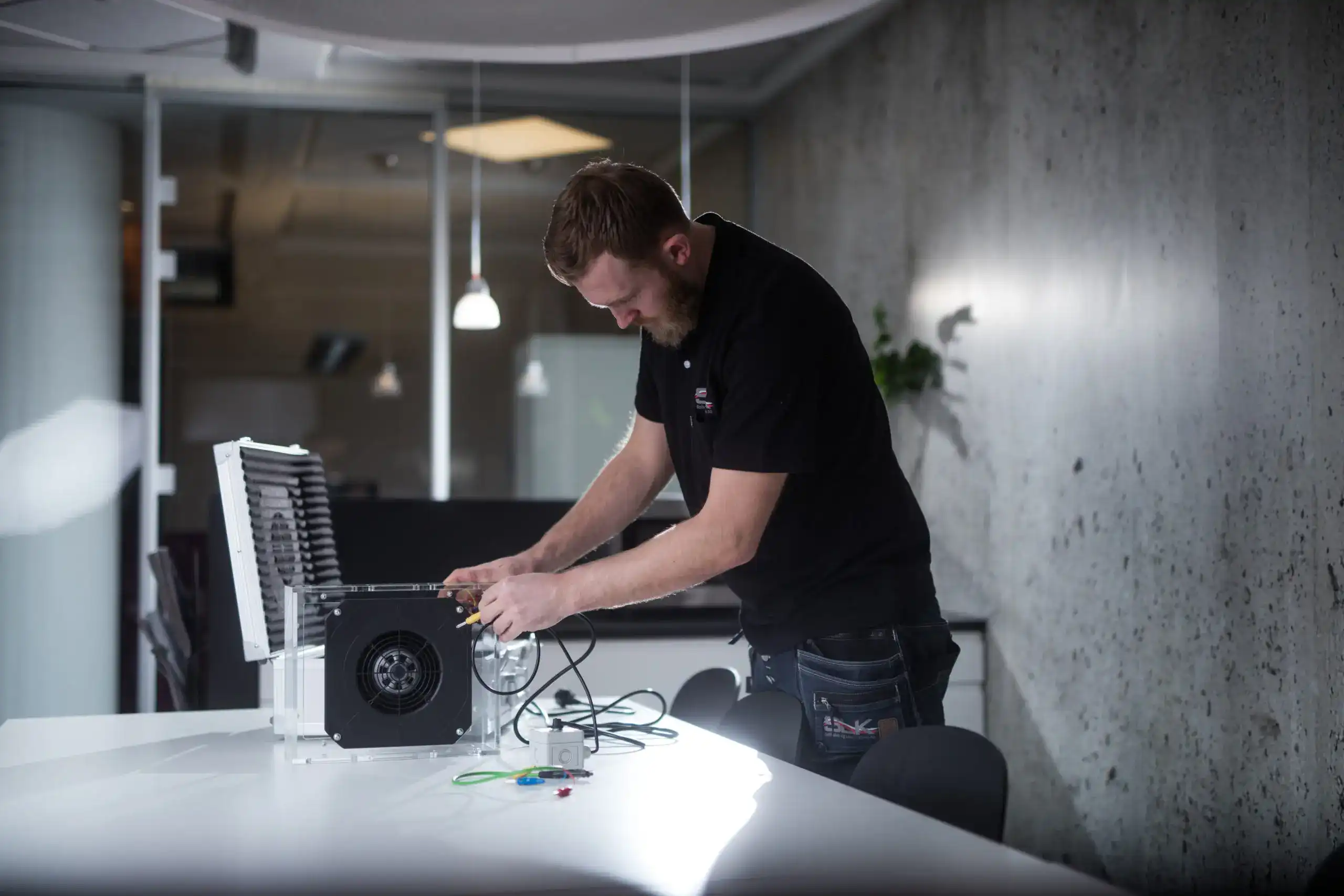 SLK - en mann i svart skjorte som jobber på en datamaskin
